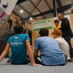 A group of young men sitting on the ground in a bouldering centre